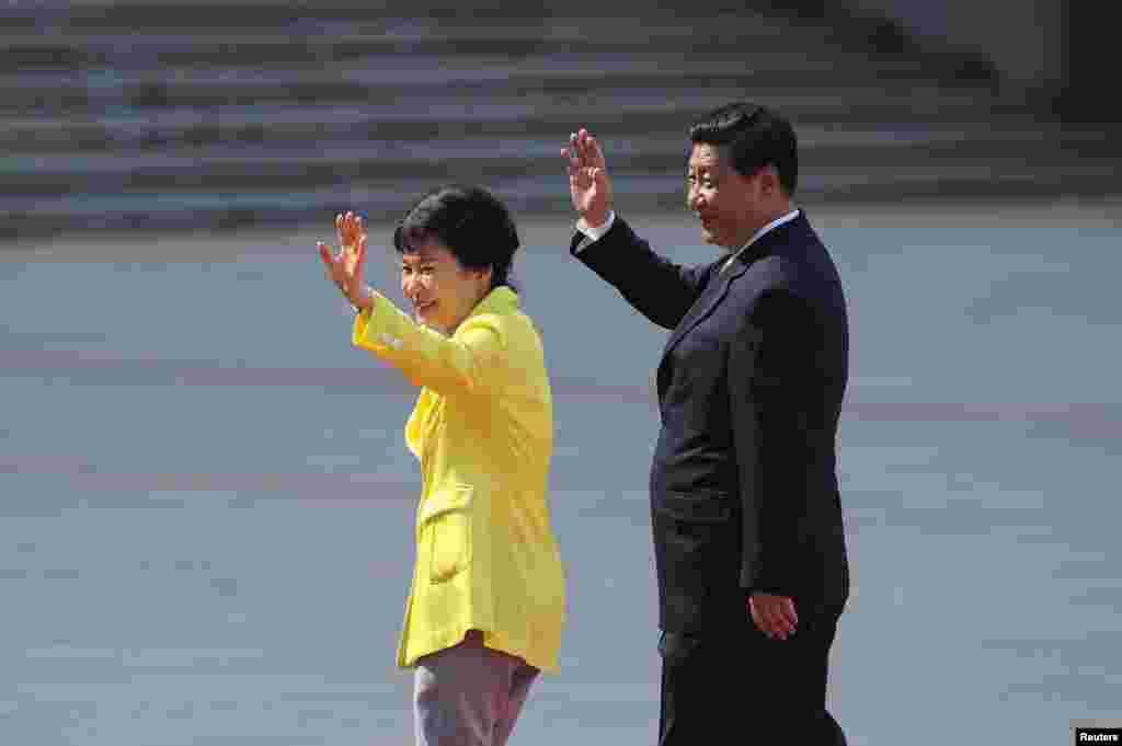 27일 중국 인민대회당 광장에서 열린 공식 환영 행사에서 박근혜 한국 대통령(왼쪽)이 시진핑 중국 공산당 국가주석과 함께 손을 흔들고 있다.