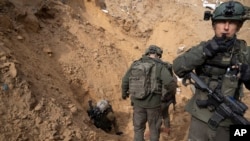 FILE - Israeli soldiers enter a Hamas tunnel underneath a cemetery during the ground offensive on the Gaza Strip in Khan Younis, January 27, 2024.