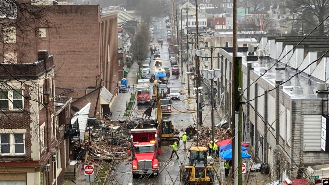 Personal de emergencia y equipo pesado en el lugar de una explosión mortal en una fábrica de chocolate en West Reading, Pensilvania, el sábado 25 de marzo. (AP Photo/Michael Rubinkam)
