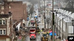 Personal de emergencia y equipo pesado en el lugar de una explosión mortal en una fábrica de chocolate en West Reading, Pensilvania, el sábado 25 de marzo. (AP Photo/Michael Rubinkam)