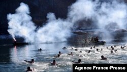 Kosovo Serbs swim in the cold water of Gazivoda Lake as part of the traditional Epiphany swimming competition, near the town of Zubin Potok, in northern Mitrovica.