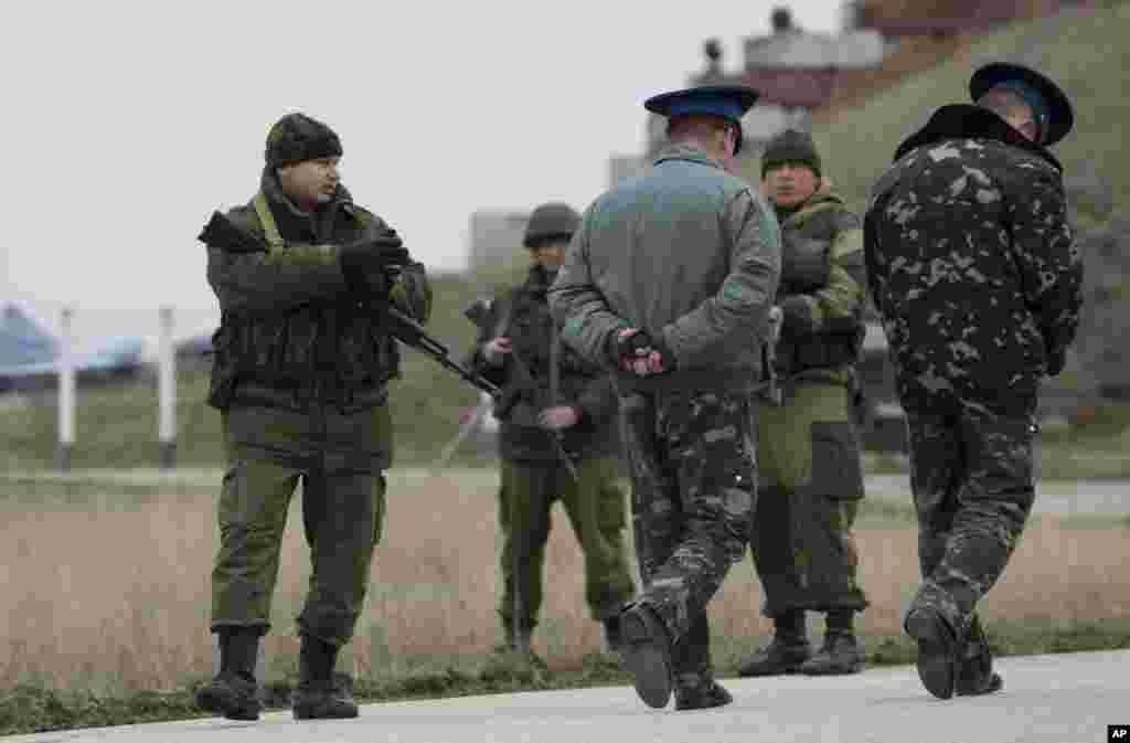 Ukrainian officers arrive for talks as Russians guard at the Belbek air base, outside Sevastopol, Ukraine, March 4, 2014.