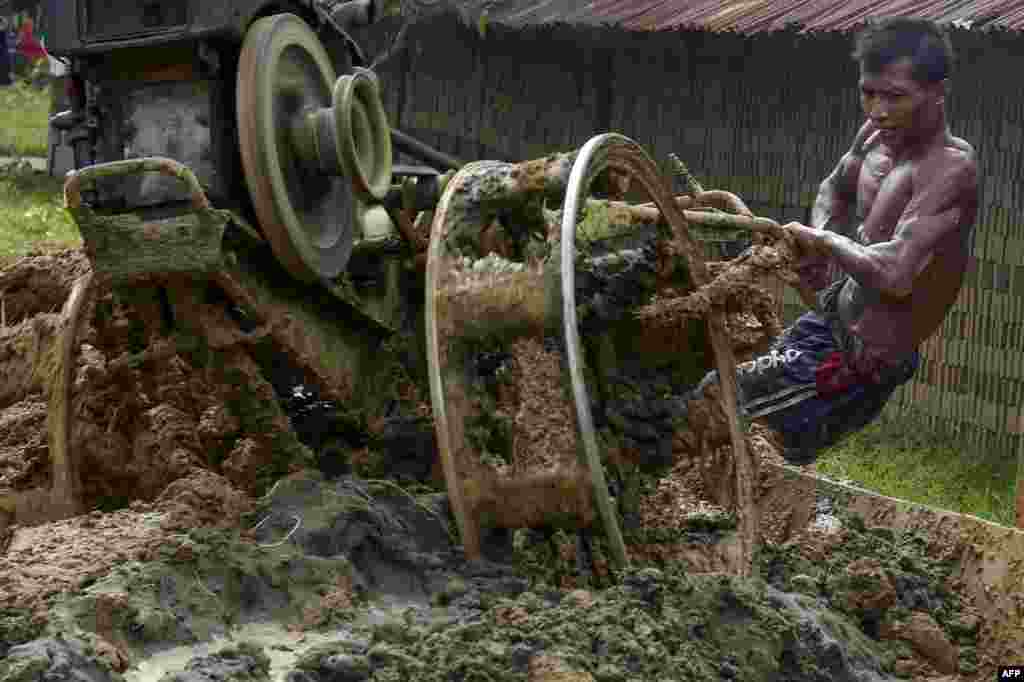 A man mixes materials to make bricks at a brick factory on the outskirts of Kajhu, Aceh province, Indonesia.