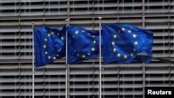 FILE - European Union flags flutter outside the EU Commission headquarters in Brussels, Belgium, May 5, 2021. 