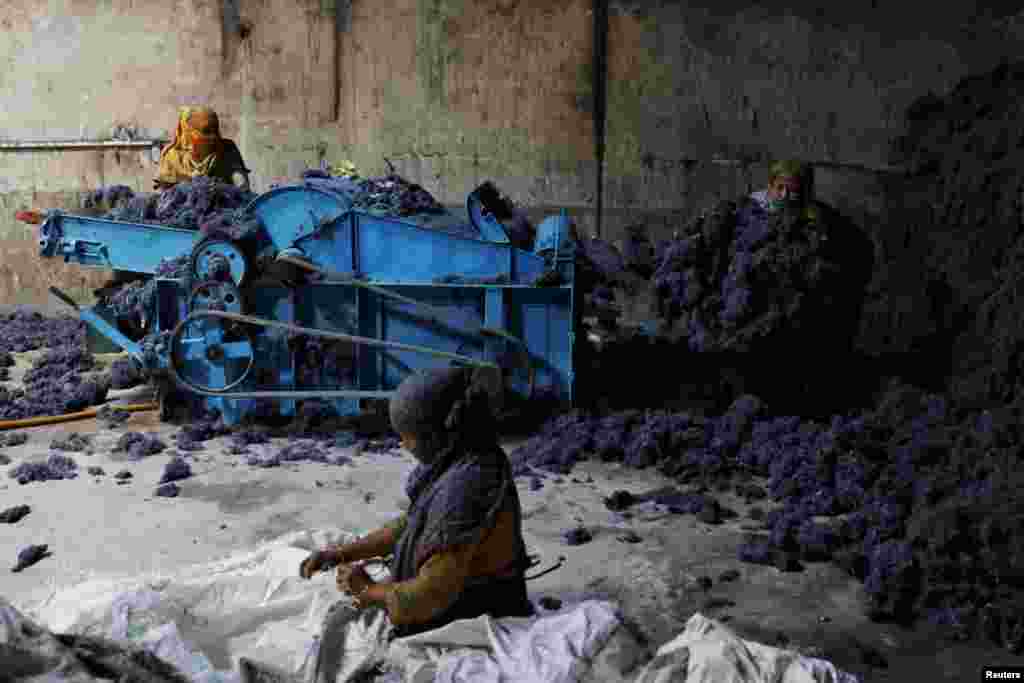 Women work in a factory where fabric waste from garments is transformed into cotton to make mattresses, in Narayanganj, Bangladesh.