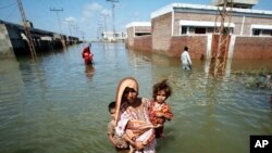 A woman escapes to higher ground from her flooded village in the Mirpur Khas district of Pakistan's Sindh province.