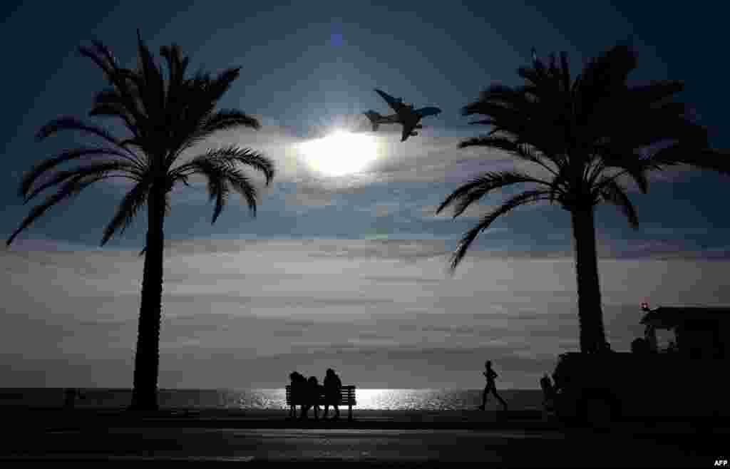 People watch an Airbus 380 approaching the Nice airport along the French Riviera.