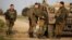 Israeli soldiers stand near a military jeep next to the border fence with the southern Gaza Strip near Kibbutz Nirim, Israel, Feb. 17, 2018.