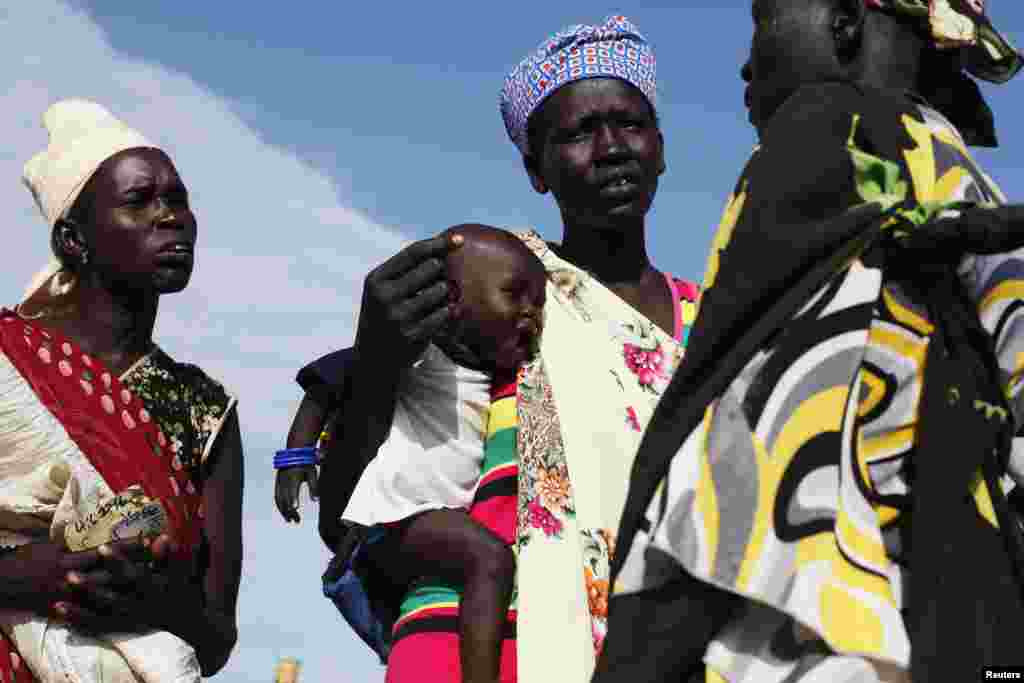 Une femme porte un bébé alors qu&rsquo;elle discute avec une autre femme au centre de distribution alimentaire à Minkaman, Etat de Lacs, Sud Soudan, le 27 juin 2017. (Reuters) 