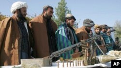FILE - Taliban fighters line up as they hand over their weapons to join the peace process in Herat, Afghanistan, Nov. 3, 2012.