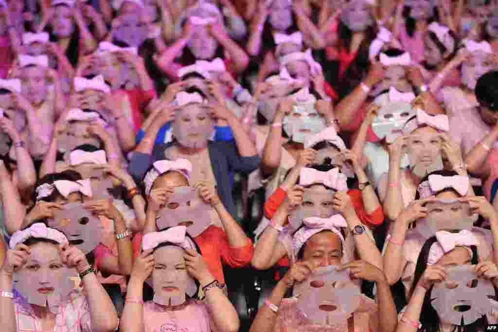 Peserta bersiap-siap untuk mengenakan topeng di Taipei, Taiwan. Sebanyak 1.213 orang memecahkan Guinness World Record dengan mengenakan topeng wajah selama 10 menit pada waktu yang bersamaan.