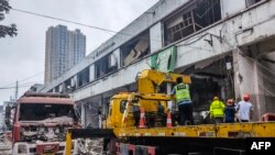 Para pekerja mencari korban di dalam gedung yang hancur akibat ledakan gas yang menewaskan 12 orang dan melukai puluhan lainnya, di Shiyan, Provinsi Hubei, China, Minggu, 13 Juni 2021. (Foto: CNS/AFP)