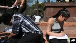 Catholics fill out forms seeking the formal renunciation of their religion in protest of the innumerous cases of sexual abuse by the clergy, in Santiago, Chile, Sept. 8, 2018.