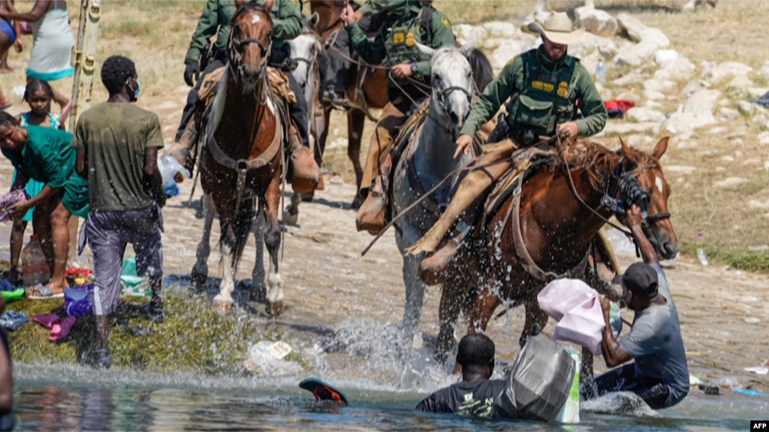 ARCHIVO - Inmigrantes haitianos son impedidos de cruzar hacia la parte estadounidense en Del Río, Texas, en septiembre de 2021.