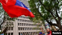 A supporter of opposition party Kuomintang waves a Taiwanese flag outside of the Central Election Commission in Taipei, Taiwan, on Nov. 24, 2023.