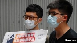 Aktivis Pro-demokrasi Hong Kong, Nathan Law dan Joshua Wong memberikan keterangan kepada media dalam menanggapi undang-undang keamanan nasional di Hong Kong, 3 Juni 2020. (REUTERS / Tyrone Siu)