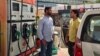 Rajesh Kumar, left, shares a ride to work with another employee, Dilip Swain, right, as higher petrol prices in India begin to be felt in people's pocketbooks.