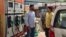 Rajesh Kumar, left, shares a ride to work with another employee, Dilip Swain, right, as higher petrol prices in India begin to be felt in people's pocketbooks.