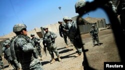 U.S. soldiers from the 2nd battalion, 32nd Field Artillery brigade listen to their superiors' orders before going on a patrol in Baghdad Aug. 14, 2007. 