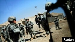 FILE - U.S. soldiers from the 2nd battalion, 32nd Field Artillery brigade listen to their superiors' orders before going on a patrol in Baghdad. 