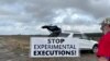 Activistas contra la pena de muerte colocan carteles a lo largo de la carretera que conduce al Centro Correccional Holman en Atmore, Alabama, antes de la ejecución programada de Kenneth Eugene Smith el 25 de enero de 2024 en Estados Unidos
