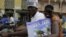 Supporters of presidential candidate Cheick Modibo Diarra distribute campaign flyers from the back of a moped as they ride in a campaign caravan through the streets of Bamako, Mali, July 20, 2013.