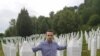 Behidin Piric, a survivor of the Srebrenica Genocide of 1995, stands next to the graves of his grandfather and great-uncles, who were killed in the massacre,while visiting the Srebrenica Memorial Center in Bosnia in 2019. 