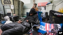 Star Wars fan, actor Deuce Wayne from Virginia rests outside the TCL Chinese Theater Imax while waiting for the premiere of "Star Wars: The Force Awakens" in Los Angeles, Dec. 9, 2015.