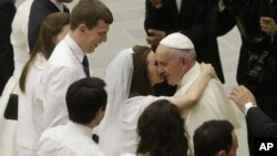 El papa Francisco saluda a una pareja de recién casados en la sala Paulo VI del Vaticano.