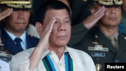 Philippine President Rodrigo Duterte salutes with military officers during a anniversary celebration of the Armed Forces at a military camp in Quezon city, Manila, Dec. 21, 2016.