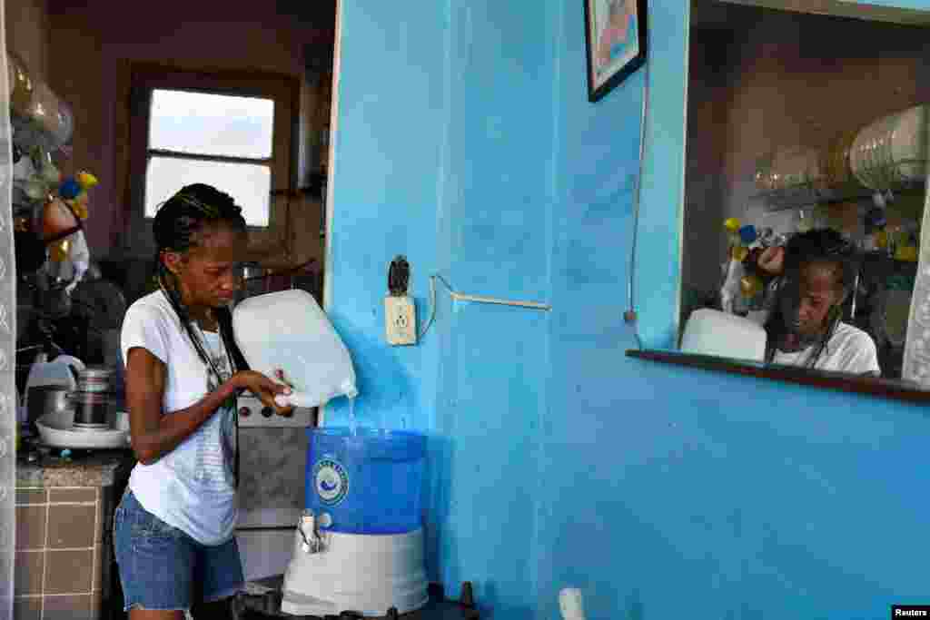 Una mujer llena un dispensador con agua de un grupo de la iglesia que ofrece a los residentes pequeñas cantidades del líquido para frenar la escasez, en La Habana, Cuba.&nbsp;