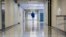 FILE - A middle school principal walks the empty halls of his school as he speaks with one of his teachers about her COVID-19 symptoms, in Wrightsville, Ga., Aug., 20, 2021. On Dec. 27, 2021, U.S. health officials cut isolation restrictions for Americans 