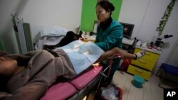FILE - A nurse examines "Nancy" Yin, three-months pregnant, at an abortion clinic run by Marie Stopes International in Xi'an in central China's Shaanxi province.