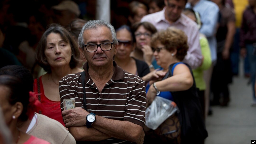 People line up to check for their signatures at data center outside of the Venezuelan National Electoral Council, CNE, headquarters, in Caracas, June 20, 2016.