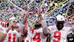 Ohio State wide receiver K.J. Hill (14) holds the trophy following the team's 34-21 win over Wisconsin in the Big Ten championship NCAA college football game, Dec. 8, 2019, in Indianapolis.
