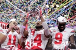FILE - Ohio State wide receiver K.J. Hill (14) holds the trophy following the team's 34-21 win over Wisconsin in the Big Ten championship NCAA college football game, Dec. 8, 2019, in Indianapolis.