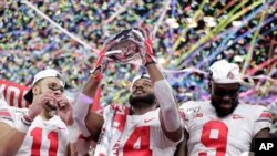 Ohio State wide receiver K.J. Hill (14) holds the trophy following the team's 34-21 win over Wisconsin in the Big Ten championship NCAA college football game, Dec. 8, 2019, in Indianapolis.