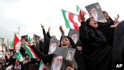 Demonstrators cry as they hold up portraits of Supreme Leader Ayatollah Ali Khamenei at a pro-government rally denouncing last week’s violent protests over a fuel price hike, in Tehran, Nov. 25, 2019.