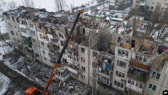 2023年2月15日救援人员在乌克兰波克罗夫斯克清理被俄罗斯火箭摧毁的住宅楼废墟，专家警告说，这场已造成双方数万人死亡、许多城市化为废墟的战争可能会持续多年。 （美联社照片）