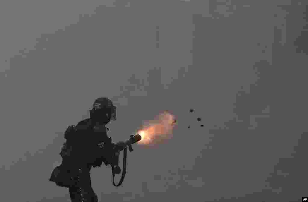 A police officer fires tear gas at protesters during a strike against tax reform, in Cali, Colombia, May 3, 2021.