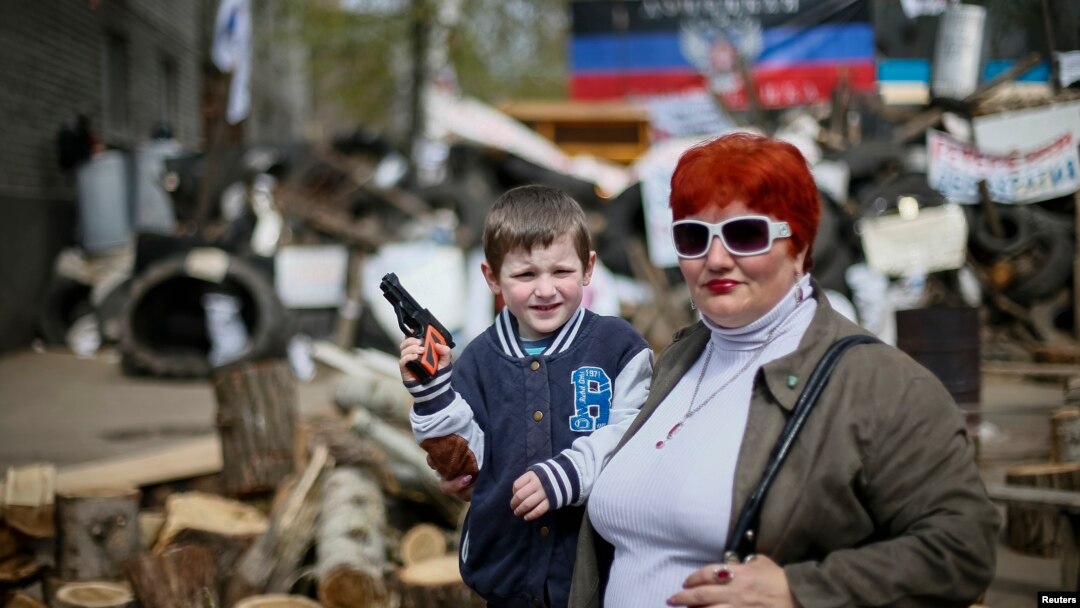 Un niño y su madre posan para una foto frente a una barricada en Slaviansk, al este de Ucrania.