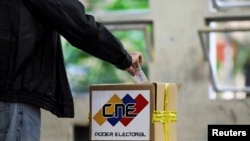 FILE - A man casts his vote at a polling station during the parliamentary election in Caracas, Venezuela, Dec. 6, 2020.
