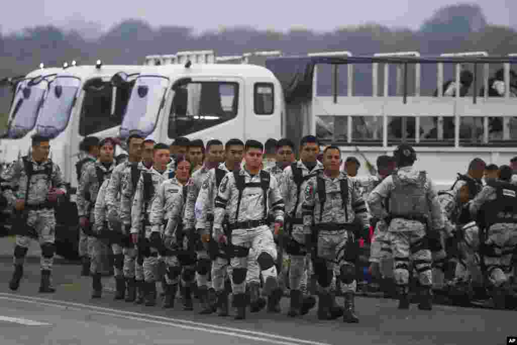 Mexican National Guards prepare to board an aircraft at the International Airport in Merida, Mexico to travel north to reinforce the country&#39;s border with the United States.