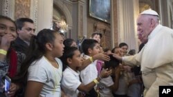 FILE - Pope Francis blesses faithful during his visit to the Morelia Cathedral in Mexico's Michoacan state, Feb. 16, 2016. The clash between the pope and Donald Trump comes just 2 days ahead of the South Carolina Republican primary, 