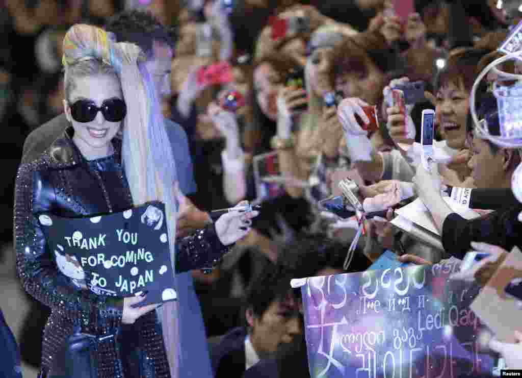 Lady Gaga memberikan tanda tangan kepada para fans sesaat setelah tiba di Bandara Internasional Narita, Tokyo, Jepang, 8 Mei (Reuters).