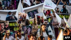 Syrian Yazidis march with pictures and banners during a demonstration in Amude, west of Qamishli, near the Syrian-Turkish border, Aug. 3, 2018, marking the fifth anniversary of IS attacks in the Sinjar mountains in Iraq's Yazidi heartland.