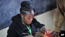 Membro da comissão eleitoral regista votos através da impressão digital dos eleitores. Escola Primária de Panarae em Kajiado, Quénia, Aug. 8, 2017. 