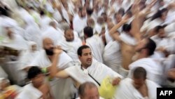 Muslim pilgrims cast stones at a pillar, symbolizing the stoning of Satan, in a ritual called "Jamarat," the last rite of the annual hajj, in Mina near the Saudi holy city of Mecca, Saudi Arabia, Sunday, Nov. 6, 2011. The annual Islamic pilgrimage draws 2