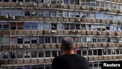 (FILE) A man looks at a building damaged at the site of an explosion, amid the Israel-Hamas conflict in Tel Aviv, Israel July 19, 2024. 