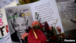 Cards and flowers are left outside the Medi-Clinic Heart Hospital, where the ailing former South African President Nelson Mandela is being treated in Pretoria, June 28, 2013. 